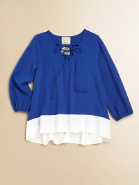 Your little girl will float away in this airy, long-sleeved pullover, defined by a lace-up neckline, colorblocked design and an on-trend hi-lo hem.Laced V-neckLong sleeves with elastic cuffsPullover styleHi-lo hemPolyesterDry cleanMade in the USA of imported fabric Your little girl will float away in this airy, long-sleeved pullover, defined by a lace-up neckline, colorblocked design and an on-trend hi-lo hem.Laced V-neckLong sleeves with elastic cuffsPullover styleHi-lo hemPolyesterDry cleanMade in the USA of imported fabric