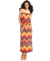 Sunny Leigh's colorful maxi dress offers a bold update on an elongated silhouette with its flattering smocking and bright zigzag design. Neutral accessories showcase this chic look to great effect.
