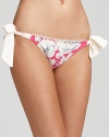 Put a sweet spin on your sunbathing look with this bow-trimmed bikini bottom from Juicy Couture. Floral and feminine, it's a pretty way to take the plunge.
