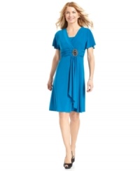 R&M Richards' dress features a figure-flattering empire waistband with pretty ruched detailing and a stunning jeweled brooch as a finishing touch. R&M Richards' dress features a figure-flattering empire waistband with pretty ruched detailing and a stunning jeweled brooch as a finishing touch.