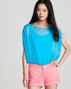 A blousy, blue Alice + Olivia top lends a light and airy touch to shorts and jeans.