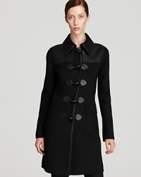 Cut a sharp silhouette in this DKNY coat, flaunting sleek tailoring and clean lines for modern sophistication. Leather insets finish the style with downtown edge. Cut a sharp silhouette in this DKNY coat, flaunting sleek tailoring and clean lines for modern sophistication. Leather insets finish the style with downtown edge.