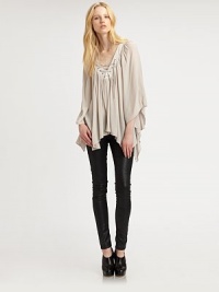 Tie-up v-neck, cape sleeves and an asymmetrical hem add old-world charm to this silk-like blouse. Tie-up v-neckThree-quarter cape sleevesAsymmetrical hits below the hips at longest pointRayonDry cleanMade in USAModel shown is 5'11 (178cm) wearing US size Small. Tie-up v-neck, cape sleeves and an asymmetrical hem add old-world charm to this silk-like blouse. Tie-up v-neckThree-quarter cape sleevesAsymmetrical hits below the hips at longest pointRayonDry cleanMade in USAModel shown is 5'11 (178cm) wearing US size Small.