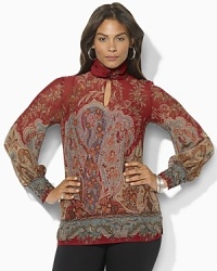A breezy blouse is finished with a buttoned mockneck and elegant puffed sleeves. A breezy blouse is finished with a buttoned mockneck and elegant puffed sleeves.