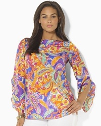 A sweeping paisley pattern and flowing silhouette combine to create the bold Reiden tunic in luxe silk. A sweeping paisley pattern and flowing silhouette combine to create the bold Reiden tunic in luxe silk.