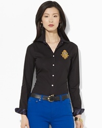 A crisp cotton poplin shirt is accented with rich heritage details, finished with tie-striped silk at the collar and an embroidered crest at the chest. A crisp cotton poplin shirt is accented with rich heritage details, finished with tie-striped silk at the collar and an embroidered crest at the chest.