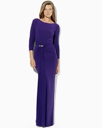 A crystal-encrusted brooch and gathering at the right waist impart sexy sophistication to a sweeping floor-length gown in figure-flattering matte jersey. A crystal-encrusted brooch and gathering at the right waist impart sexy sophistication to a sweeping floor-length gown in figure-flattering matte jersey.