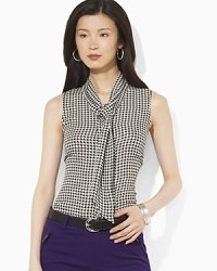 A bold houndstooth pattern sweeps across a silk georgette blouse, accented with scarf ties at the neckline for a glamorous finish. A bold houndstooth pattern sweeps across a silk georgette blouse, accented with scarf ties at the neckline for a glamorous finish.