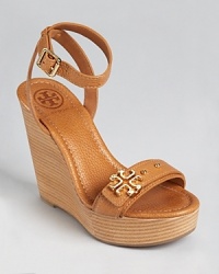 Atop a tall stacked wedge, the Tory Burch Elina sandals lend heightened style.