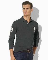A trim-fitting long-sleeved polo shirt is rendered in breathable cotton mesh with higher armholes and a shorter hem than the classic. A trim-fitting long-sleeved polo shirt is rendered in breathable cotton mesh with higher armholes and a shorter hem than the classic.