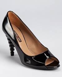 A sculpted heel adds a modern architectural touch to a classic peep toe silhouette from Bruno Magli, an unexpected detail that makes a major statement. A sculpted heel adds a modern architectural touch to a classic peep toe silhouette from Bruno Magli, an unexpected detail that makes a major statement.