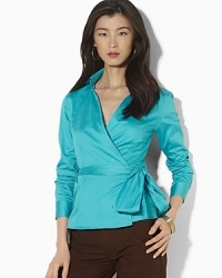 A feminine wrap blouse is crafted in luxurious cotton sateen for a modern, sophisticated look. A feminine wrap blouse is crafted in luxurious cotton sateen for a modern, sophisticated look.