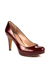 VINCE CAMUTO's mid heel pumps shine in metallic patent leather, demanding to be admired.