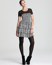 A black-and-white palette lends city sophistication to a leopard-print DKNY dress, finished with a ruffled skirt for a roaring fashion statement. A black-and-white palette lends city sophistication to a leopard-print DKNY dress, finished with a ruffled skirt for a roaring fashion statement.