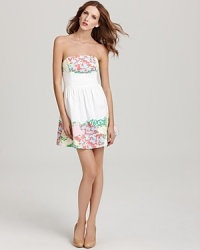 A beautiful floral sketch print sweeps across the bodice and hem of this Lilly Pulitzer strapless dress, designed to fit close at the top, then elegantly releasing into a full, flirty skirt. A beautiful floral sketch print sweeps across the bodice and hem of this Lilly Pulitzer strapless dress, designed to fit close at the top, then elegantly releasing into a full, flirty skirt.