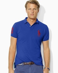 Designed with a trim cut through the body and a shorter hem, this short-sleeved polo shirt is crafted from breathable cotton mesh with Ralph Lauren's Big Pony. Designed with a trim cut through the body and a shorter hem, this short-sleeved polo shirt is crafted from breathable cotton mesh with Ralph Lauren's Big Pony.