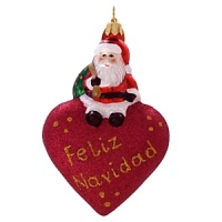 A little Santa sits atop a glittered puffed heart to wish you a Feliz Navidad. A little Santa sits atop a glittered puffed heart to wish you a Feliz Navidad.