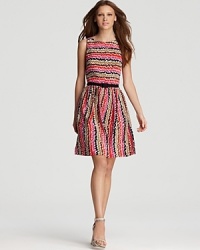 A colorful zigzag print brightens up this Trina Turk day dress, cinched with a black grosgrain belt and featuring a demure pleated skirt. A colorful zigzag print brightens up this Trina Turk day dress, cinched with a black grosgrain belt and featuring a demure pleated skirt.