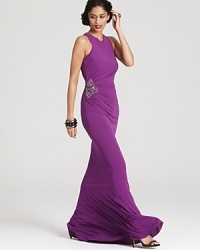 Flaunting a potent hue, this floor-sweeping David Meister gown is adorned with a sparkling rhinestone embellishment at the waist for heightened drama. Flaunting a potent hue, this floor-sweeping David Meister gown is adorned with a sparkling rhinestone embellishment at the waist for heightened drama.