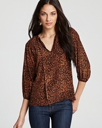 In lively leopard, Tucker's animal printed top showcases a split neck with tie details. In lively leopard, Tucker's animal printed top showcases a split neck with tie details.