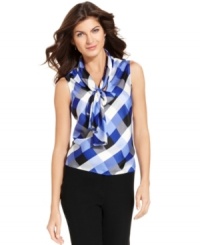 Nine West's classic tie-front blouse gets a fresh look with a chic checked pattern that's perfect for adding punch to your work wardrobe. Nine West's classic tie-front blouse gets a fresh look with a chic checked pattern that's perfect for adding punch to your work wardrobe.