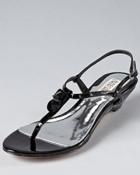 Two geometric embellishments adorn glossy patent leather on these dressed-up Badgley Mischka sandals, with a subtle wedge that takes the design to glamorous heights. Two geometric embellishments adorn glossy patent leather on these dressed-up Badgley Mischka sandals, with a subtle wedge that takes the design to glamorous heights.