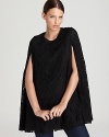 This DKNY cape ushers in this season's new gothic with a dramatic silhouette emblazoned by decadent lace. Slip on the style and infuse your staples with dark romance.