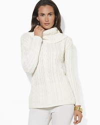 A soft cable-knit sweater is knit from a plush blend of wool, angora and cashmere yarns and finished with elegant buttons at the cowl neckline. A soft cable-knit sweater is knit from a plush blend of wool, angora and cashmere yarns and finished with elegant buttons at the cowl neckline.