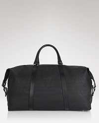 With a textured linen shell and leather accents, this weekender totes your overnight essentials in classic style. With a textured linen shell and leather accents, this weekender totes your overnight essentials in classic style.