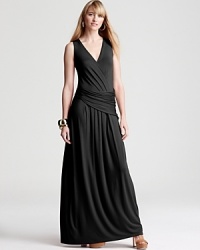 Artful draping brings dramatic movement to the floor-sweeping silhouette of this Elie Tahari dress. Amp up the glamour factor with touches of gold for an enchanting evening look. Artful draping brings dramatic movement to the floor-sweeping silhouette of this Elie Tahari dress. Amp up the glamour factor with touches of gold for an enchanting evening look.