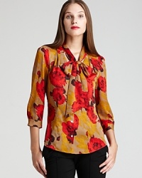 Vibrant blossoms freshen a classic AK Anne Klein blouse, finished with a decadent bow collar for a decidedly romantic style. Vibrant blossoms freshen a classic AK Anne Klein blouse, finished with a decadent bow collar for a decidedly romantic style.