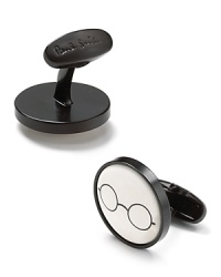 A whimsical pair of cufflinks honoring the legendary John Lennon features his iconic glasses on a simple background of white. A whimsical pair of cufflinks honoring the legendary John Lennon features his iconic glasses on a simple background of white.