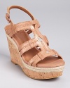 Subtly geometric in metallic leather, these shimmering sandals boast a cork wedge and stitched raffia trim at the midsole. From Lucky Brand.