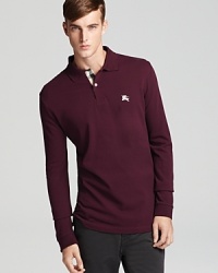 Exude effortless style with Burberry Brit's classic long sleeve polo. Exude effortless style with Burberry Brit's classic long sleeve polo.