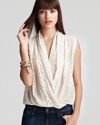 Dress up your look with a touch of shimmer, compliments of this metallic-dot Aqua blouse with crossover neckline, blouson bodice and cinched elastic hemline. Dress up your look with a touch of shimmer, compliments of this metallic-dot Aqua blouse with crossover neckline, blouson bodice and cinched elastic hemline.