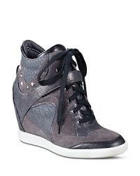 GUESS takes the sporty sneaker to new heights with a dramatic hidden wedge and tapered almond toes. GUESS takes the sporty sneaker to new heights with a dramatic hidden wedge and tapered almond toes.