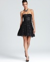 Matte black sequins lend understated sparkle to a strapless BCBGMAXAZRIA dress, crafted with a flared, tiered skirt for a playful finish.
