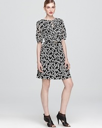 Ladylike with an edge, this Trina Turk dress of stretch silk flaunts a graphic print and wispy faux-patent belt. Ladylike with an edge, this Trina Turk dress of stretch silk flaunts a graphic print and wispy faux-patent belt.