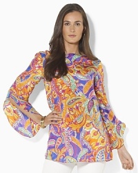 A sweeping paisley pattern and flowing silhouette combine to create the bold Reiden tunic in luxe silk. A sweeping paisley pattern and flowing silhouette combine to create the bold Reiden tunic in luxe silk.
