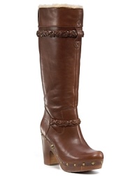 Lined in sumptuous shearling and adorned with intricate braids, these clog-inspired boots are an on-trend essential. By UGG® Australia. Lined in sumptuous shearling and adorned with intricate braids, these clog-inspired boots are an on-trend essential. By UGG® Australia.