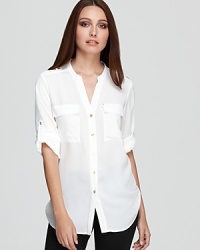 This roll-sleeve Calvin Klein shirt showcases stunning gold-tone accents against a sleek utilitarian silhouette for everyday effortless polish. This roll-sleeve Calvin Klein shirt showcases stunning gold-tone accents against a sleek utilitarian silhouette for everyday effortless polish.