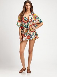 A breezy coverup with a vivid floral print. V-neckFlutter sleevesEmpire waistSelf-tieCottonDry cleanImported