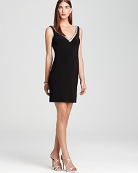 A deep double v neck is detailed in sparkling rhinestones on this timelessly elegant Basix dress. A deep double v neck is detailed in sparkling rhinestones on this timelessly elegant Basix dress.