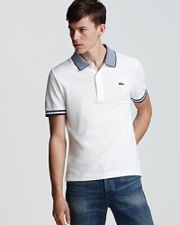 Thin stripes at the collar and sleeve edge differentiate this cool Lacoste polo from a crowded sea of pique solids. Thin stripes at the collar and sleeve edge differentiate this cool Lacoste polo from a crowded sea of pique solids.