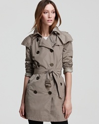 Master utilitarian city style in this Burberry Brit trench coat, finished with a generous hood to halt a bad hair day before it starts. Master utilitarian city style in this Burberry Brit trench coat, finished with a generous hood to halt a bad hair day before it starts.