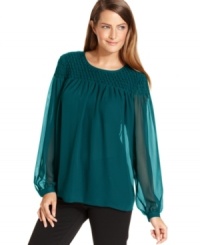 Calvin Klein's bishop-sleeve blouse features a textured pattern at the chest and shoulders and sheer, alluring detail at the sleeves. Calvin Klein's bishop-sleeve blouse features a textured pattern at the chest and shoulders and sheer, alluring detail at the sleeves.