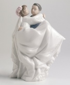 A celebration of marriage as the groom carries his bride over the threshold. Crafted by Lladró, Spain's most esteemed artisans of porcelain figurines.