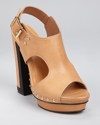 Sleek side cutouts add a unique touch to a clog-inspired sandal from VINCE CAMUTO, boasting gleaming gold-tone studs and an oversized buckle closure. Sleek side cutouts add a unique touch to a clog-inspired sandal from VINCE CAMUTO, boasting gleaming gold-tone studs and an oversized buckle closure.
