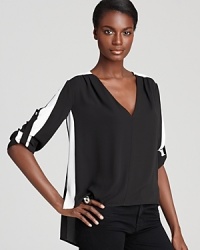 A bold contrast bewitches this BCBGMAXAZRIA top with a striking stripe of white and relaxed, boxy fit--ideal for pairing with slim skinny jeans. A bold contrast bewitches this BCBGMAXAZRIA top with a striking stripe of white and relaxed, boxy fit--ideal for pairing with slim skinny jeans.