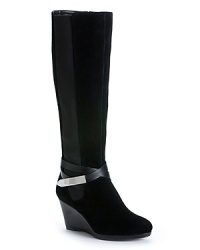 Calvin Klein moves this design one step past basic, wrapping up these tall, suede wedge boots with distinctive ankle wrap details. Calvin Klein moves this design one step past basic, wrapping up these tall, suede wedge boots with distinctive ankle wrap details.